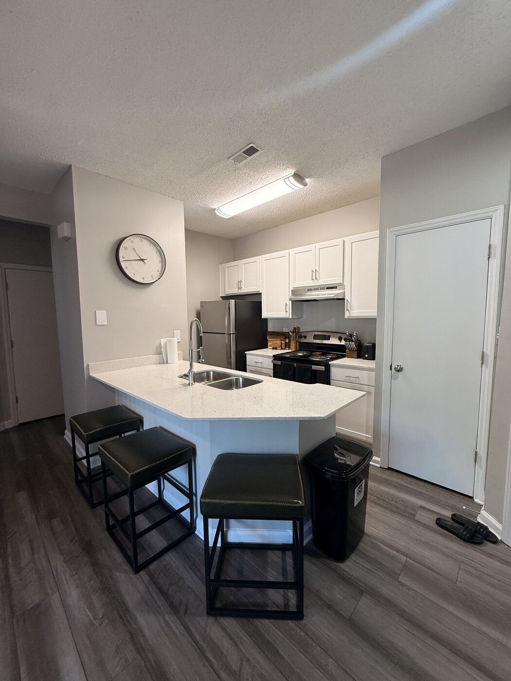 Kitchen with island seating, stove, and refrigerator