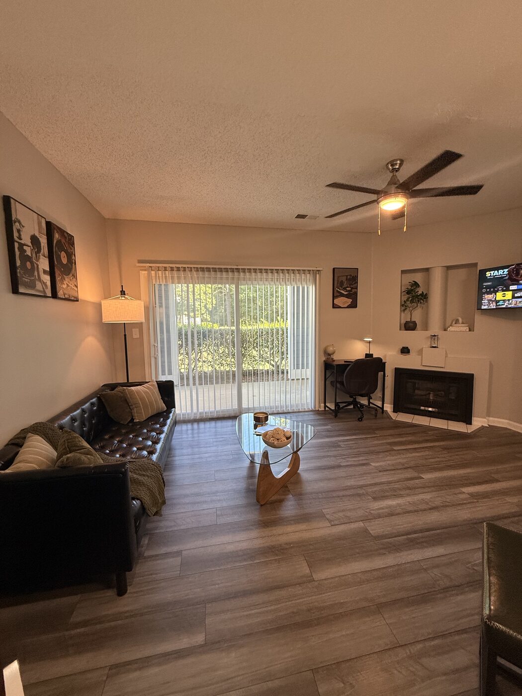 Living room with fireplace, mounted TV, and desk workspace